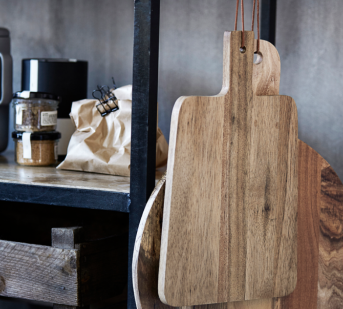 Wooden cutting boards hanging on a wall with a rustic background