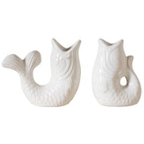 Two white ceramic mermaid tail vases on a white background