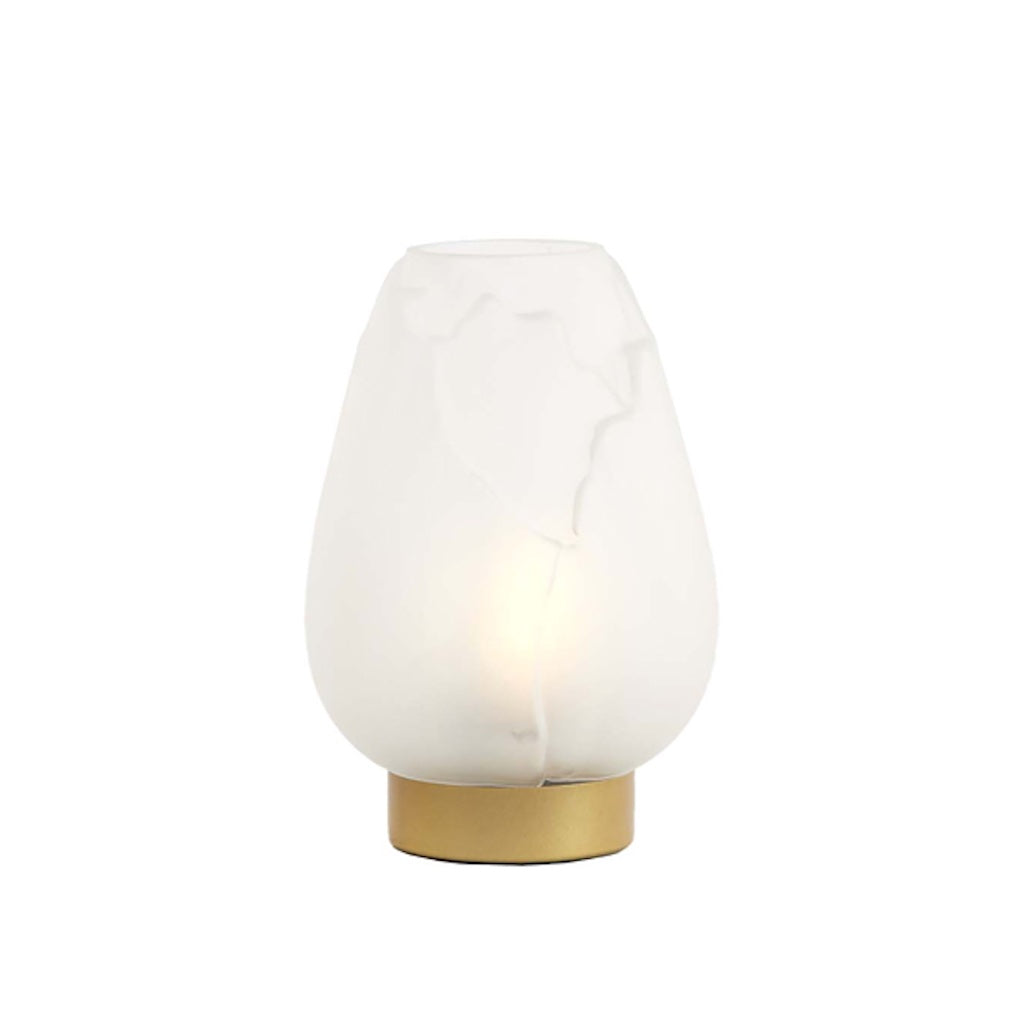 Table lamp with white shade and gold base on a white background