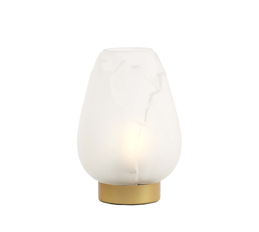 Table lamp with white shade and gold base on a white background