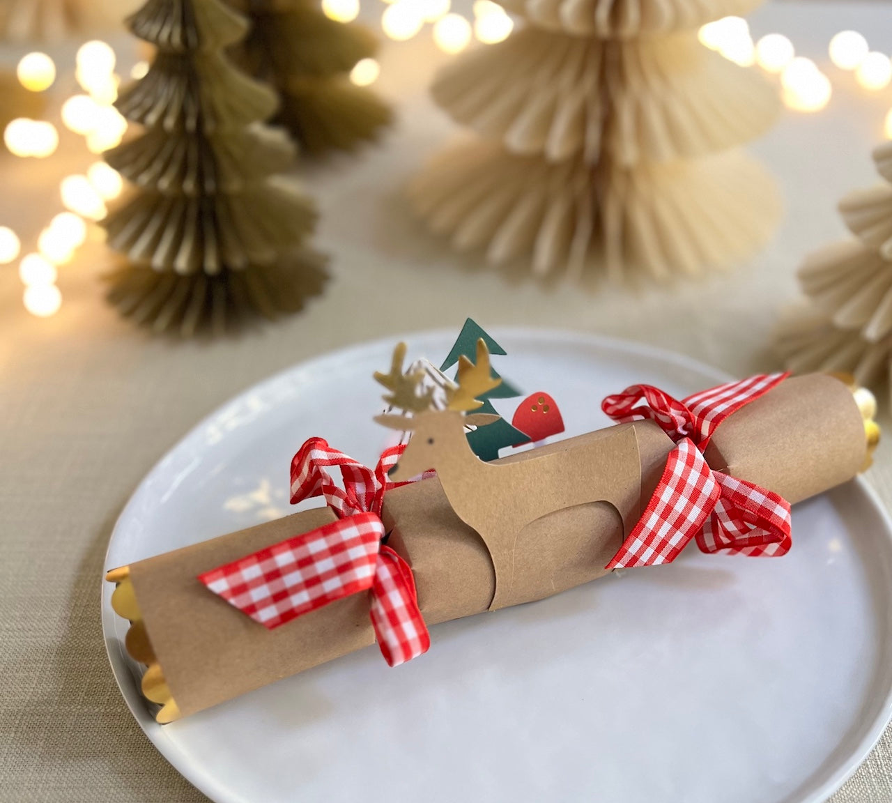 Christmas cracker with reindeer detail and red and white bows in table setting