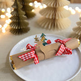 Christmas cracker with reindeer detail and red and white bows in table setting