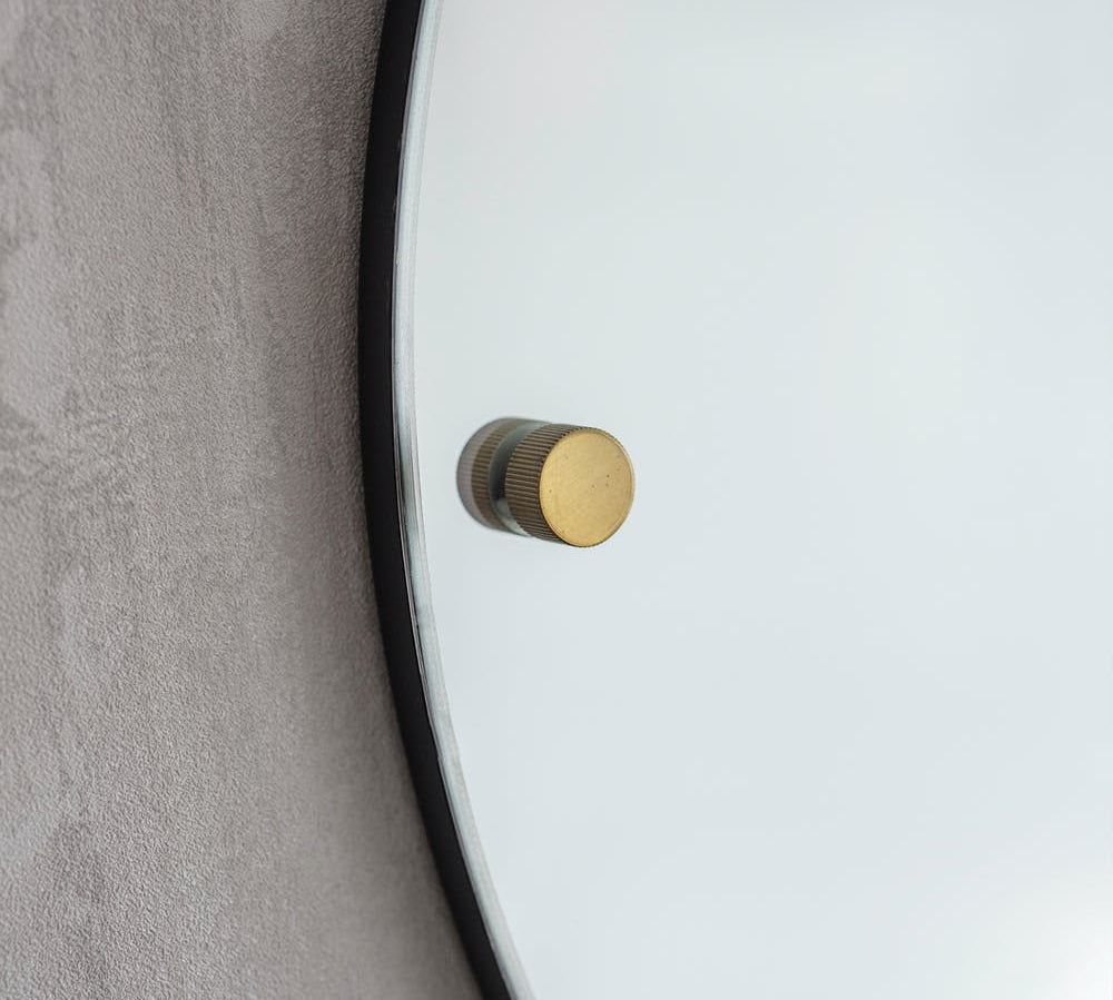 large round mirror with brass detail 