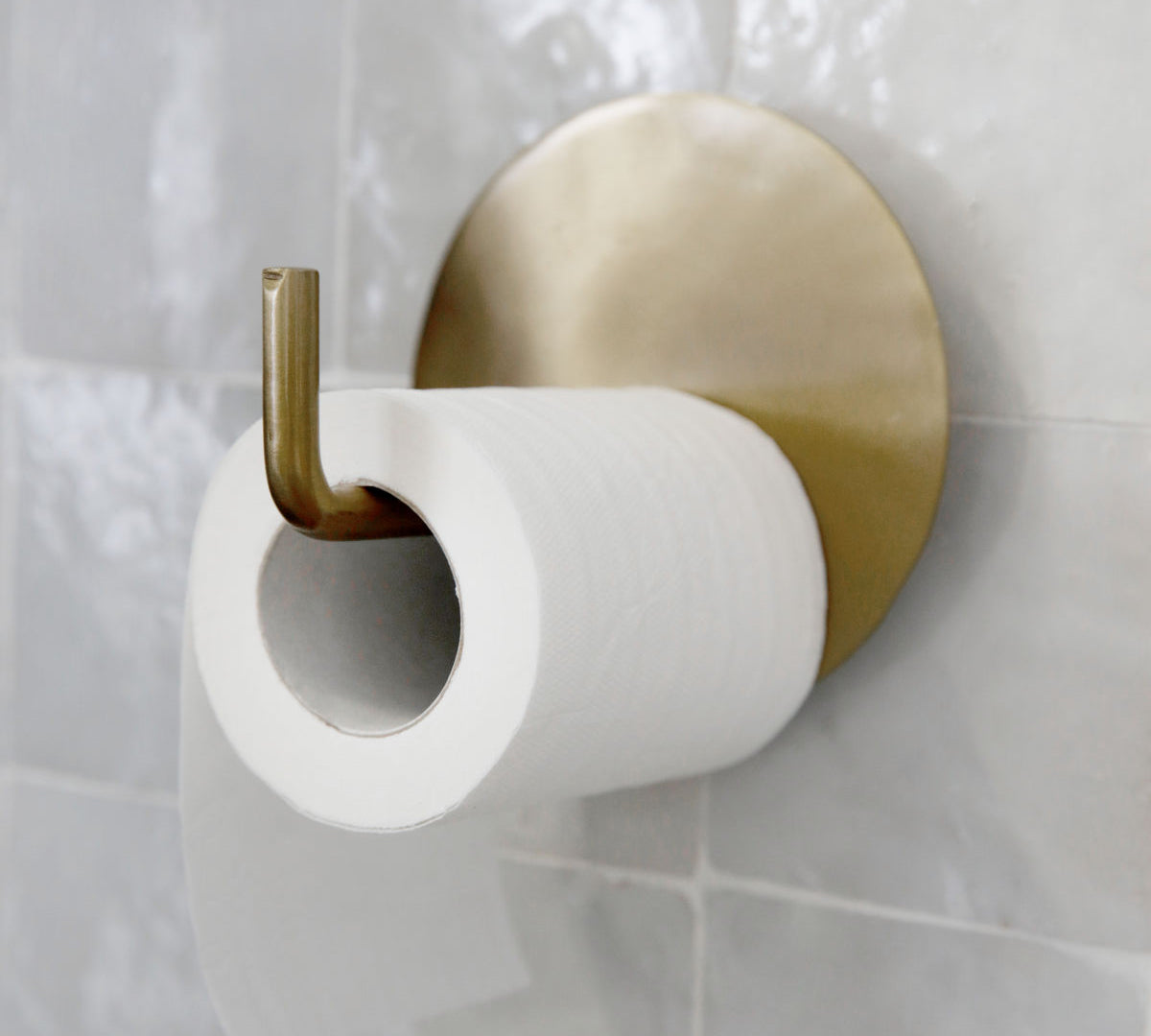 brass toilet roll holder in a simple modern style