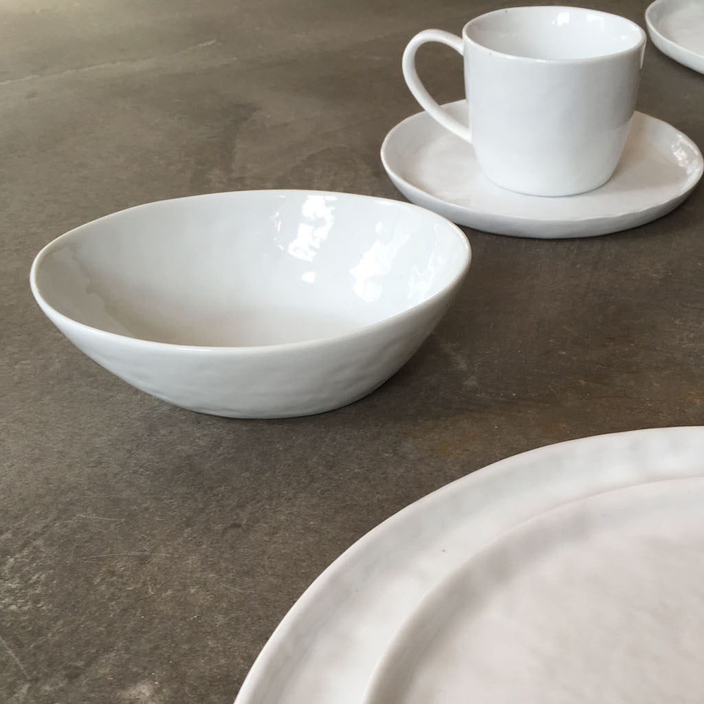 white porcelain teacup and saucer